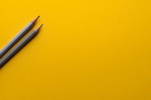 Two pencils on a yellow background