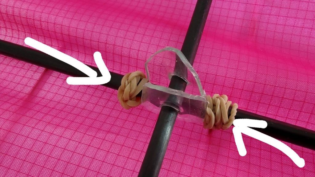 Slide both rubber bands to the centre piece